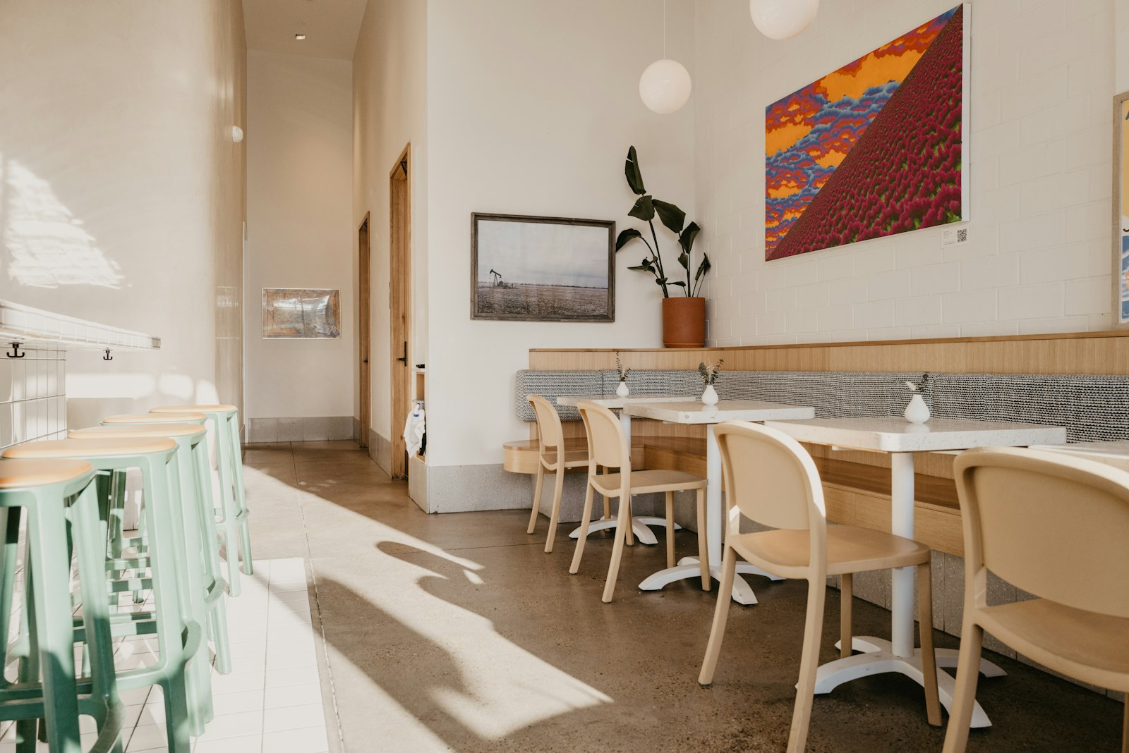 Interno luminoso del caffè con sedie colorate e arte alle pareti