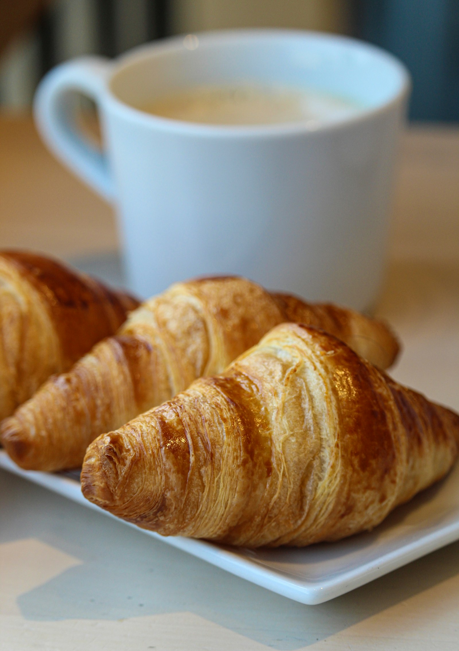 Croissant dorato appena sfornato su piatto di ceramica