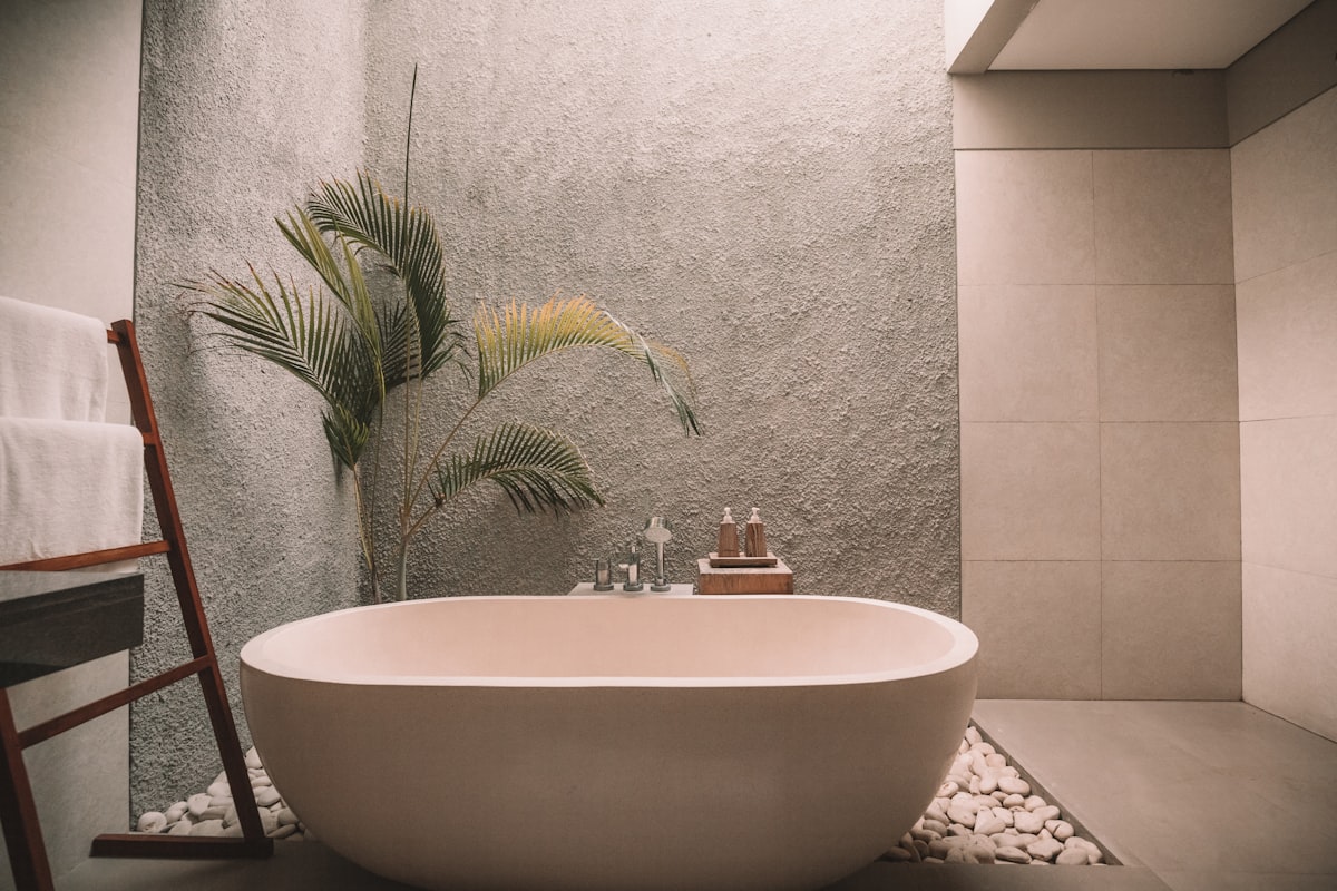 Dettaglio bagno suite con vasca freestanding e pianta tropicale