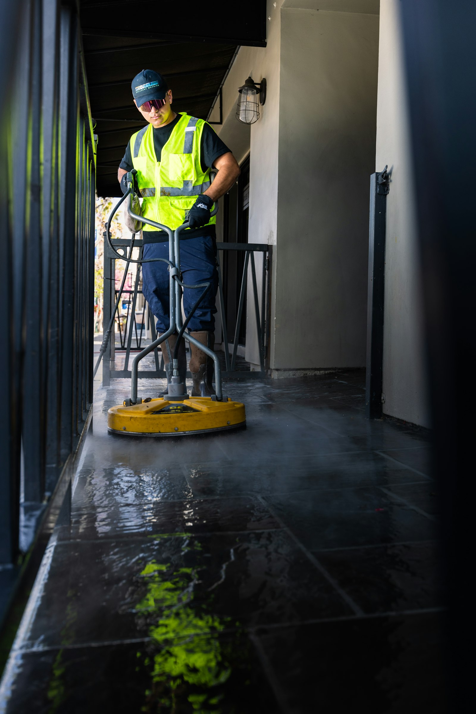 Operatore con idropulitrice professionale in intervento post cantiere