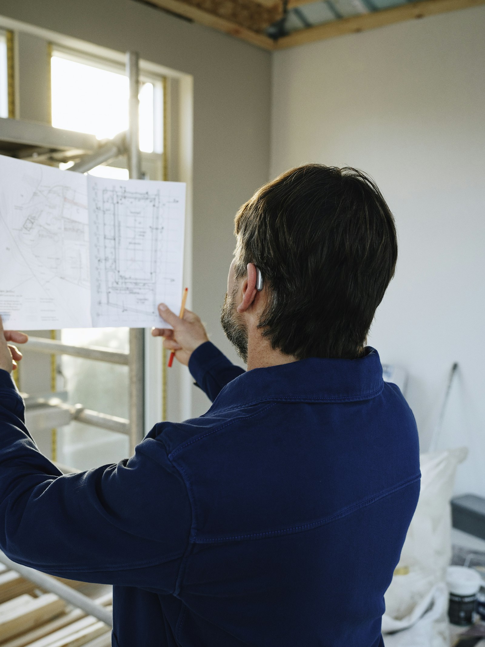 Tecnico edile che esamina planimetria in cantiere
