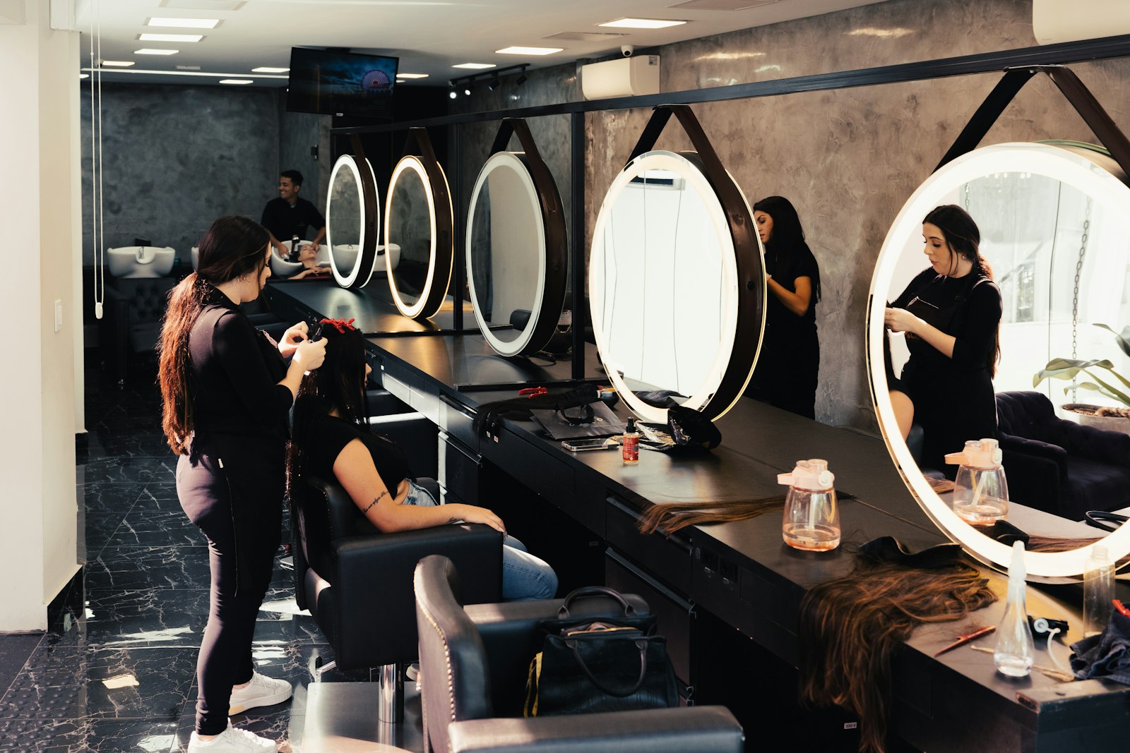 Interno del salone Studio 28 con specchi illuminati e postazioni moderne