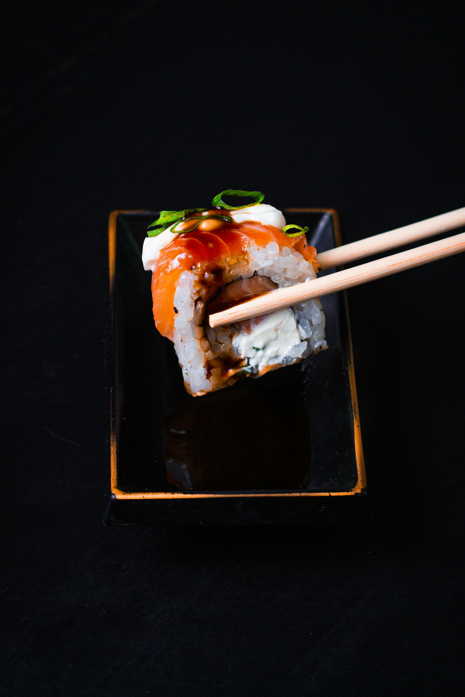 Uramaki con salmone e teriyaki su piatto nero — L'Esperienza Omakase da Nami